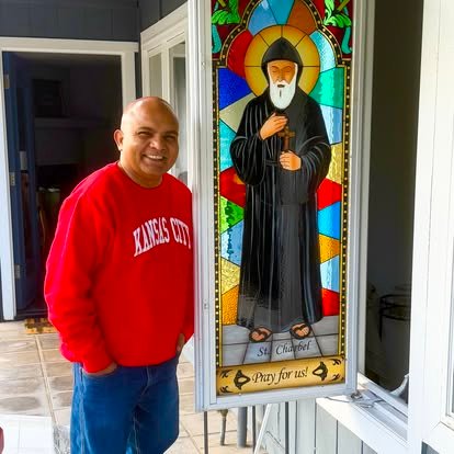 Un miembro de la comunidad junto a un vitral de san Juan Eudes